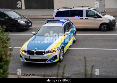 Augsbourg, Bavière, Allemagne - 04 novembre 2024 : voiture de patrouille de police avec des feux bleus et sirène de la police bavaroise à Augsbourg Souabe, debout de l'autre côté de la route dans la circulation et bloquant la route, pendant la grève d'avertissement IG Metall de MAN. *** Steifenwagen mit Blaulicht und Martinshorn der bayrischen Polizei in Augsburg Schwaben, steht quer über der Straße im Verkehr und sperrt die Fahrbahn ab, beim IG Metall Warnstreik der MAN. Banque D'Images