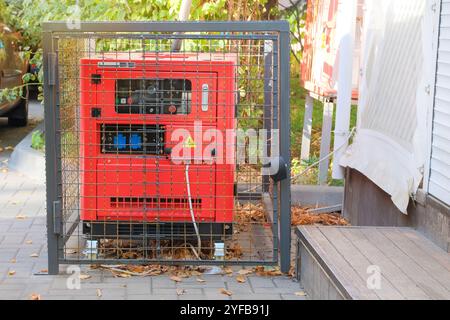 Generator utilise un café avec une terrasse extérieure en automne. Générateur d'énergie diesel extérieur. Générateur d'alimentation électrique placé sur le trottoir de la rue. Banque D'Images