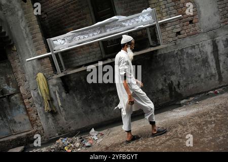 Un musulman indien passe devant le cadavre de Bhure Ali lors de ses funérailles dans la région de Mustafabad à l'est de Delhi, en Inde, le 4 mars 2020. Ali, un ouvrier a quitté la maison le 24 février avant le début des émeutes à East delhi et avait disparu depuis lors. Son corps a été sorti d'un canal le 3 mars et a été remis à la famille aujourd'hui. Banque D'Images