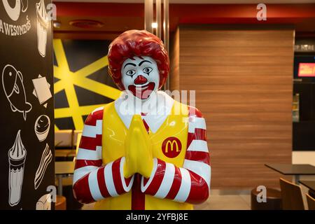 BANGKOK, THAÏLANDE - 14 OCTOBRE 2023 : statue de Ronald McDonald grandeur nature accueillant les clients avec le traditionnel message thaïlandais Wai au restaurant McDonald's. Banque D'Images