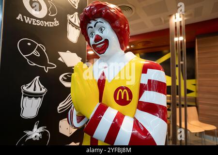 BANGKOK, THAÏLANDE - 14 OCTOBRE 2023 : statue de Ronald McDonald grandeur nature accueillant les clients avec le traditionnel message thaïlandais Wai au restaurant McDonald's. Banque D'Images