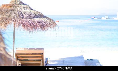 Plage d'été avec eau turquoise et sable doré, concept de vacances sous la lumière du soleil... Banque D'Images