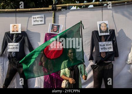 Dhaka, Bangladesh. 04th Nov, 2024. Un manifestant agite le drapeau national du Bangladesh à côté d'une effigie du premier ministre évincé Sheikh Hasina (C) lors d'une manifestation symbolique contre le fascisme au centre enseignant-étudiant de l'Université de Dhaka. Des manifestants manifestent contre le fascisme à Dacca. la commission de réforme constitutionnelle du Bangladesh, nouvellement nommée à la suite de la révolution étudiante qui a renversé l'autocrate de longue date Sheikh Hasina, a juré le 3 novembre de supprimer le « fascisme » pour sauvegarder la démocratie crédit : SOPA images Limited/Alamy Live News Banque D'Images