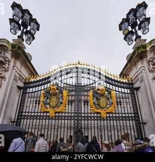 Les touristes se tiennent devant les principales portes de fer du palais de Buckingham, Londres, Angleterre. Banque D'Images