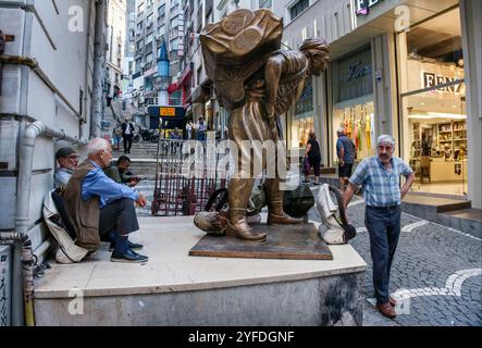 Porteurs se reposant à côté de la statue de porter, Istanbul, Turquie Banque D'Images