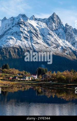 Près de la montagne enneigée de Higravtindan, la plus haute montagne de l'île d'Austvagoya, se trouve le petit village de Lilland sur l'île des Lofoten Banque D'Images