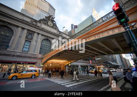 Grand Central terminal à New York City avec des piétons traversant sous le pont Pershing Square, et un taxi jaune à proximité. Banque D'Images