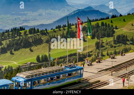 Rigi Railways wagon devant le drapeau à la gare Rigi Kulm par une journée ensoleillée d'été, les touristes appréciant la vue sur les alpes suisses Banque D'Images