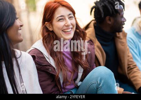 Groupe d'amis multiculturels appréciant le temps décontracté ensemble. Portrait franc de jeunes qui traînent et partagent des moments heureux en hiver Banque D'Images