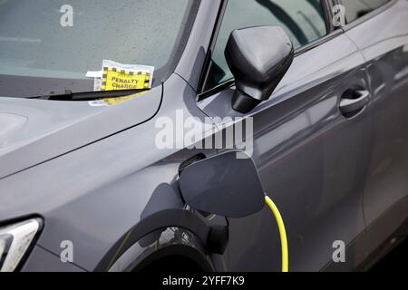 Une voiture électrique reçoit un ticket de parking au Wythenshawe Forum Banque D'Images