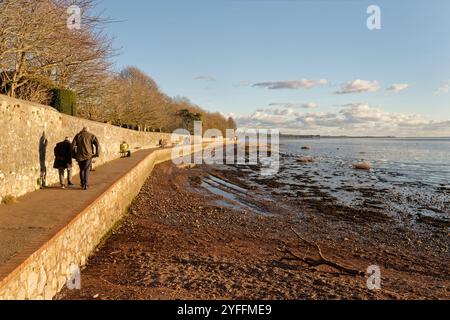 People Walking Along the Goat Walk by the Exe Estuary à Topsham au crépuscule, Devon, Royaume-Uni, janvier 2024. Banque D'Images