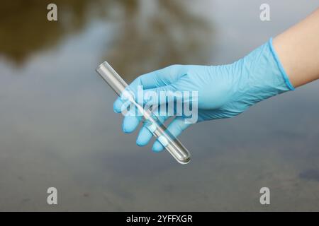 Examen de la qualité de l'eau. Chercheur tenant un tube à essai avec échantillon à l'extérieur, gros plan Banque D'Images