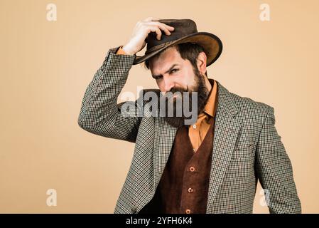 Beau cow-boy hipster à l'ancienne dans un chapeau de cow-boy. Des cowboys américains. Portrait d'homme barbu portant un chapeau de cow-boy. Style cow-boy. Cow-boy rétro Banque D'Images