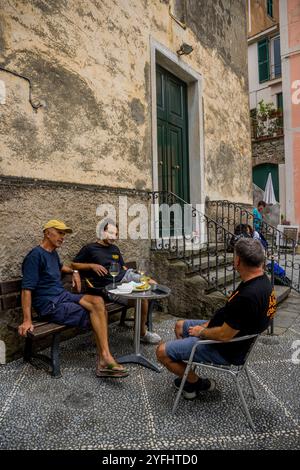 Scène de ruelle avec des hommes locaux dans le village de Corniglia, Cinque Terre, province de la Spezia, partie de la région de Ligurie, Italie du Nord. Banque D'Images