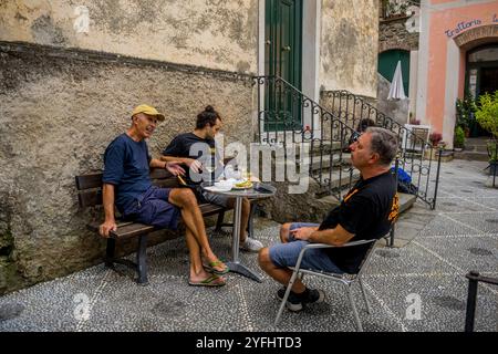 Scène de ruelle avec des hommes locaux dans le village de Corniglia, Cinque Terre, province de la Spezia, partie de la région de Ligurie, Italie du Nord. Banque D'Images