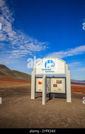 Un panneau situé à un retrait en bordure de route sur la route Dempster marquant la frontière entre le Yukon et les Territoires du Nord-Ouest Banque D'Images