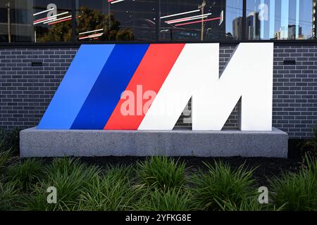 Logo BMW M illuminé, dans un jardin à l'extérieur d'un concessionnaire BMW Banque D'Images