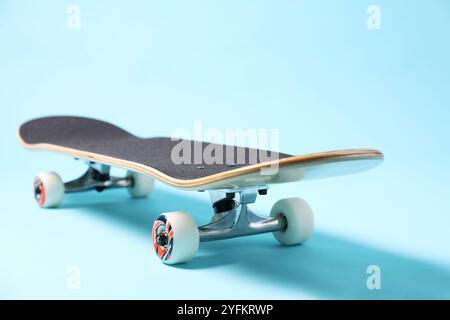 Un skateboard sur fond bleu clair, gros plan. EQUIPEMENT sportif Banque D'Images
