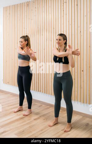 Deux femmes en forme étirant les bras avant la séance d'entraînement physique Banque D'Images