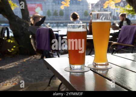 Verres de bière sur la table avec les touristes et la rivière en arrière-plan Allemagne Banque D'Images