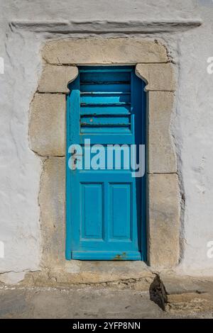 Vieille porte bleue texturée dans un mur blanc en Grèce Banque D'Images