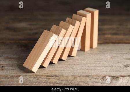 Effet domino. Blocs de bois tombant sur la table, gros plan Banque D'Images