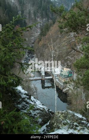 un petit barrage sur une rivière dans une vallée entre les rochers. Il y a l'heure d'hiver Banque D'Images