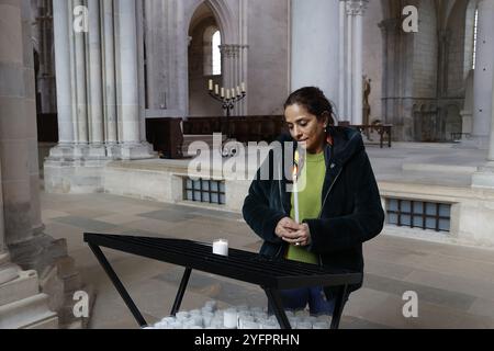 Femme tenant une bougie dans l'abbaye de Vézelay, dans la basilique Sainte-Marie-Madeleine, Yonne, France Banque D'Images