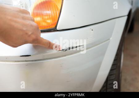 Vérification manuelle des rayures et des dommages tout en ramassant une voiture pour l'esthétique automobile professionnelle Banque D'Images