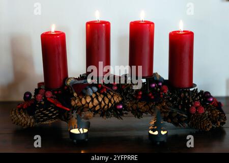 Couronne ou couronne naturelle de l'AVENT avec quatre bougies rouges allumées. Composition de Noël. Banque D'Images