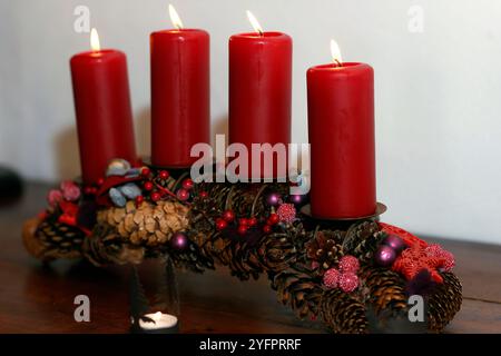 Couronne ou couronne naturelle de l'AVENT avec quatre bougies rouges allumées. Composition de Noël. Banque D'Images