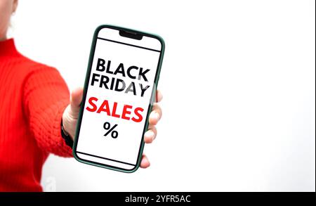 Gros plan d'une femme tenant un smartphone avec écran affichant une vente en ligne Black Friday Banque D'Images