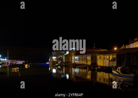 Les hangars de bateau de Batson Creek reflétés dans le miroir comme la surface de l'eau, pris la nuit créant un reflet frappant. Banque D'Images