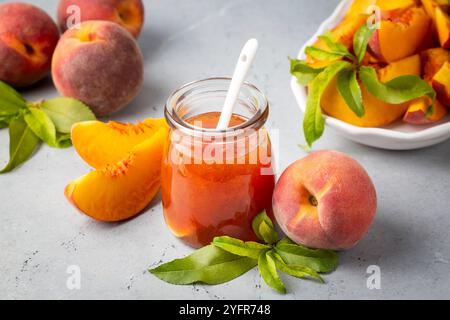 Confiture de pêches maison dans un pot avec quelques pêches fraîches, Banque D'Images