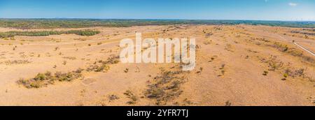 Une vue aérienne panoramique du désert serbe Deliblatska Pescara révèle une vaste étendue de plaines vides et de collines ondulantes sous un ciel clair Banque D'Images