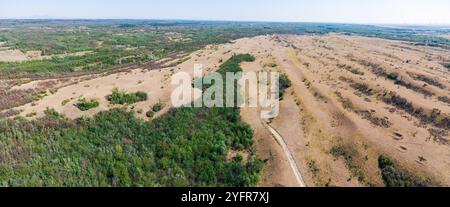 Une vue aérienne panoramique du désert serbe Deliblatska Pescara révèle une vaste étendue de plaines vides et de collines ondulantes sous un ciel clair Banque D'Images