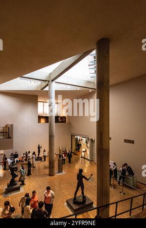 Les visiteurs explorent une galerie d'art présentant des sculptures et de la lumière naturelle dans un espace architectural moderne Banque D'Images