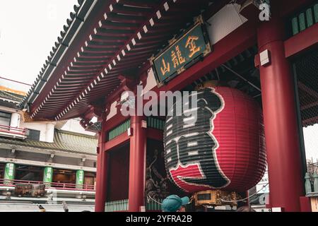 Une grande lanterne rouge suspendue à l'entrée d'un temple au Japon, présentant des conceptions complexes et une architecture traditionnelle Banque D'Images