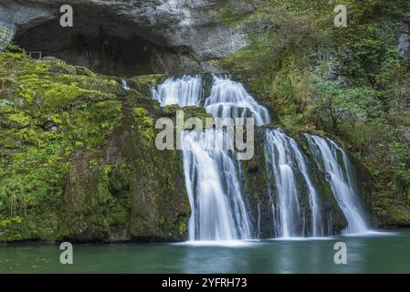 Cascade de la source du Lison dans un havre de paix avec sa cascade entourée de forêt. Nans-sous-Sainte-Anne, Doubs, Bourgogne-Franche-Co Banque D'Images