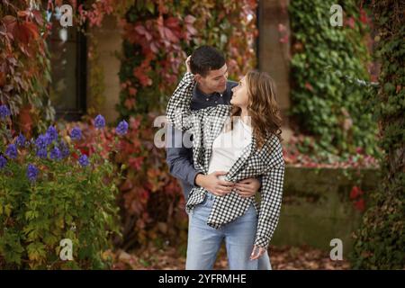 Young Cute Female Hugs Boyfriend. En automne en plein air. Amoureux marchant dans le parc. Couple drôle attrayant. Lovestory à Forest. Homme et femme. Amoureux mignons Banque D'Images