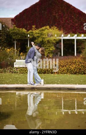 Un couple amoureux embrasse sur le rivage d'un étang de la ville dans la ville européenne. histoire d'amour dans le contexte de la nature d'automne. ambiance romantique, couple go Banque D'Images