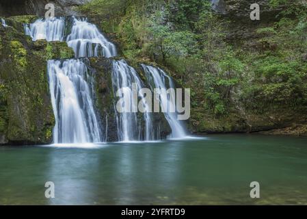 Cascade de la source du Lison dans un havre de paix avec sa cascade entourée de forêt. Nans-sous-Sainte-Anne, Doubs, Bourgogne-Franche-Co Banque D'Images