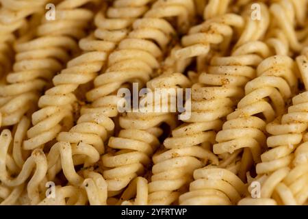 séchez les nouilles roulées aux œufs pendant la cuisson avec des épices, détails des nouilles à la farine en gros plan Banque D'Images