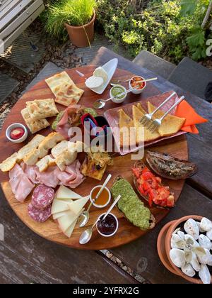 Plateau de charcuterie italien servi lors d'un apéritif typique dans les vignes de Corniglia, Cinque Terre, Italie, par une soirée nuageuse d'été Banque D'Images