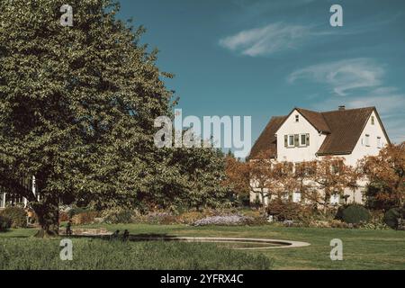 Maison avec beau jardin à l'automne. Fleurs dans le parc. Bietigheim-Bissingen. Allemagne, Europe. Parc et maison d'automne, personne, brousse et énergie Banque D'Images