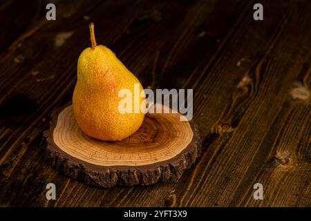 une poire jaune-rouge mûre humide sur la table, de délicieuses poires jaunes aux côtés rouges recouvertes de gouttes d'eau Banque D'Images