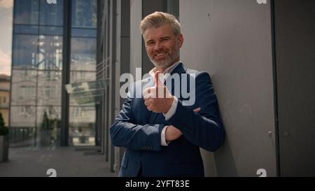 Souriant vieil homme caucasien senior mature retraité homme d'affaires homme d'affaires d'âge moyen entrepreneur d'affaires bon heureux d'accord recommander de montrer le pouce Banque D'Images