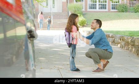 Père avec voiture qui dépose sa fille devant les portes de l'école Banque D'Images