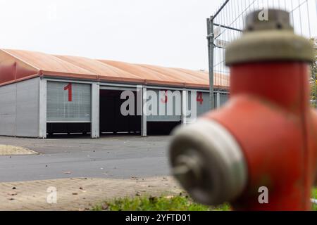Stadtallendorf, Allemagne. 05 novembre 2024. Un hall léger sur une partie du parking du Herrenwaldstadion sert de hall temporaire pour les véhicules des pompiers de Stadtallendorf. Le 16 octobre, le nouveau hall des véhicules sur le site des pompiers, dans lequel ils n'avaient emménagé qu'en décembre dernier, a brûlé avec les véhicules. Crédit : Christian Lademann/dpa/Alamy Live News Banque D'Images
