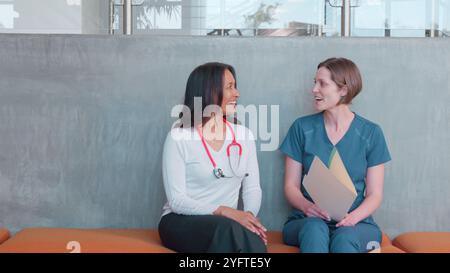 Deux membres féminins de l'équipe médicale ou chirurgicale portant des gommages se réunissant à l'hôpital Banque D'Images